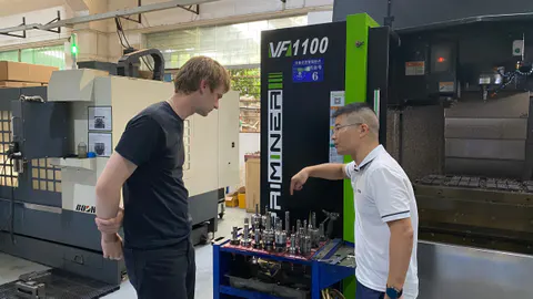 A visitor discussing manufacturing equipment with a workshop specialist