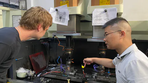 A visitor and engineer discussing manufacturing equipment in Shenzhen