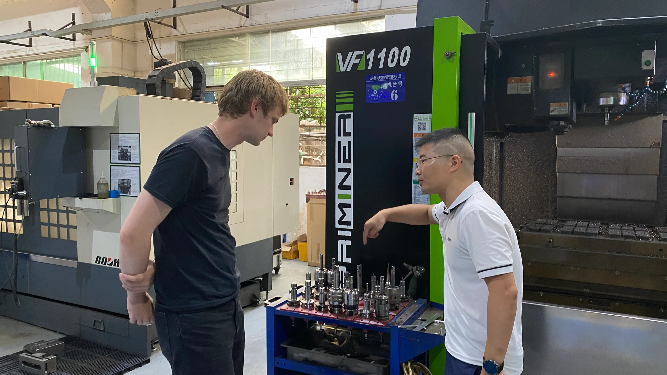A founder discussing machining details with a Shenzhen factory operator